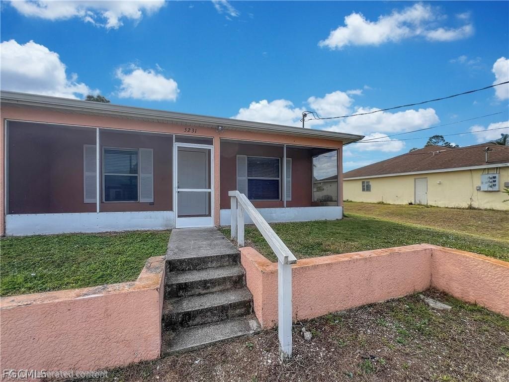 5231 27th Street Southwest Lehigh Acres, FL 33973 - Photo 2 of 22 a front view of a house with a yard