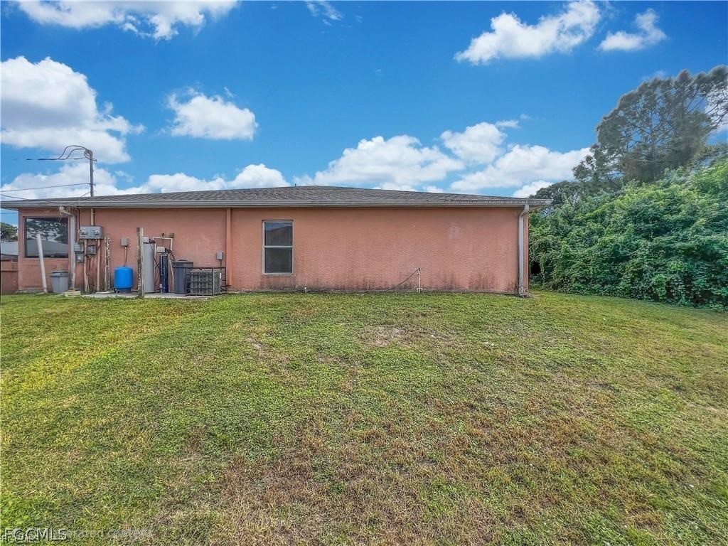 5231 27th Street Southwest Lehigh Acres, FL 33973 - Photo 22 of 22 a front view of house with yard and trees in the background