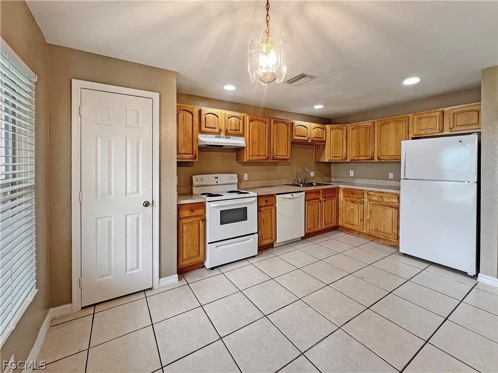 5231 27th Street Southwest Lehigh Acres, FL 33973 - Photo 9 of 22 a kitchen with a sink a refrigerator and cabinets