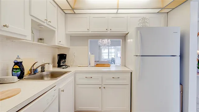 a kitchen with a sink a refrigerator and cabinets