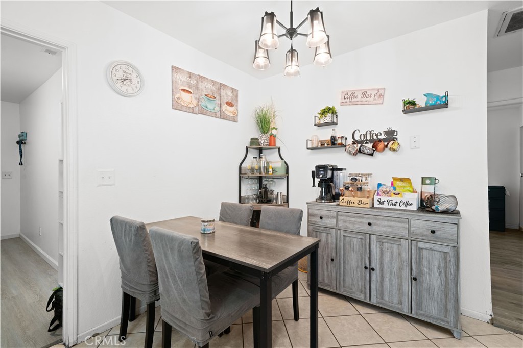 18859 6th Street Bloomington, CA 92316 - Photo 11 of 31 a kitchen with a dining table and cabinets
