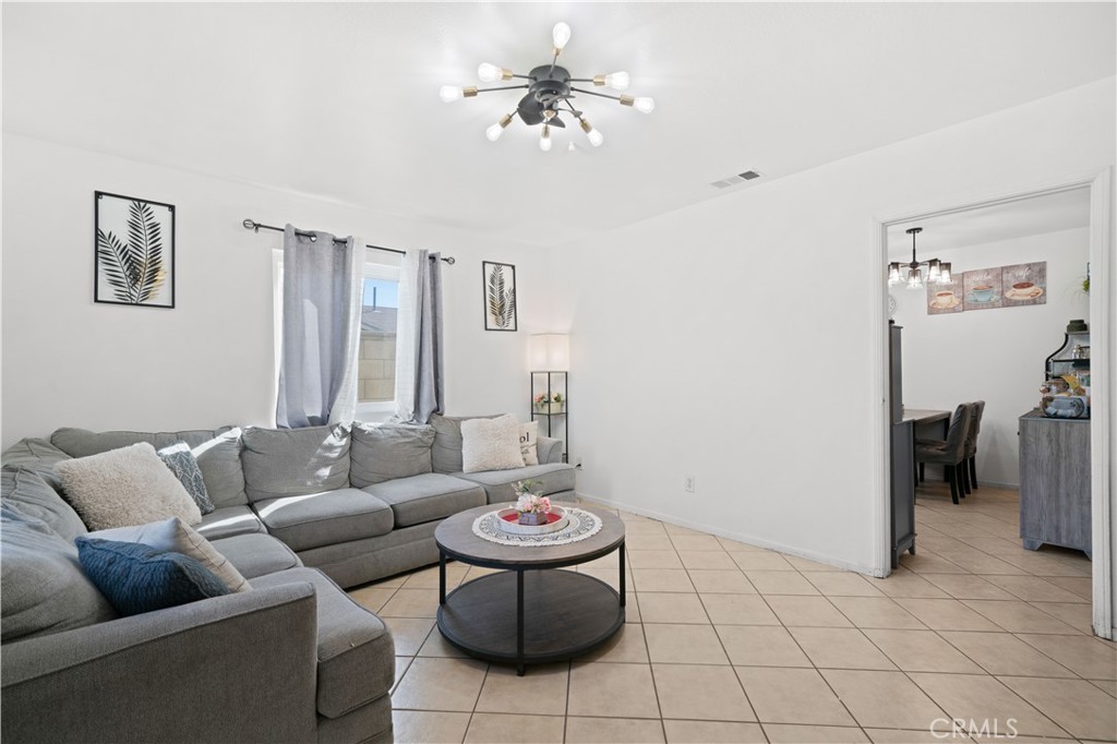 18859 6th Street Bloomington, CA 92316 - Photo 4 of 31 a living room with furniture and a chandelier