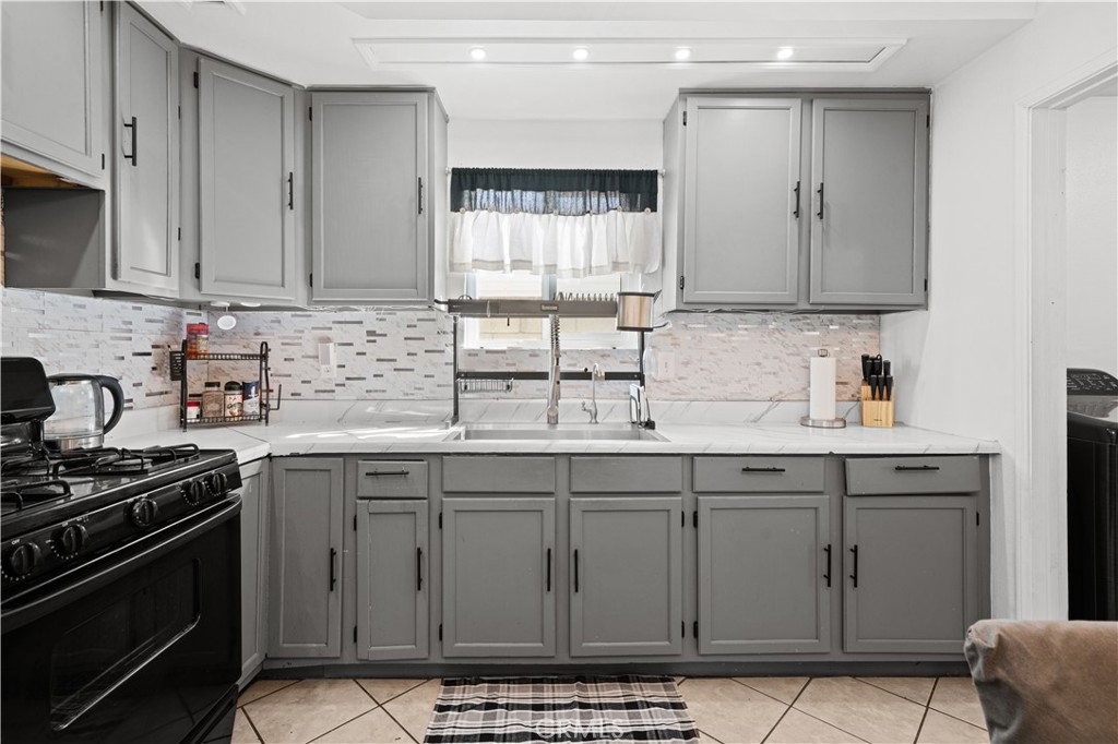 18859 6th Street Bloomington, CA 92316 - Photo 8 of 31 a kitchen with stainless steel appliances granite countertop a sink stove and cabinets