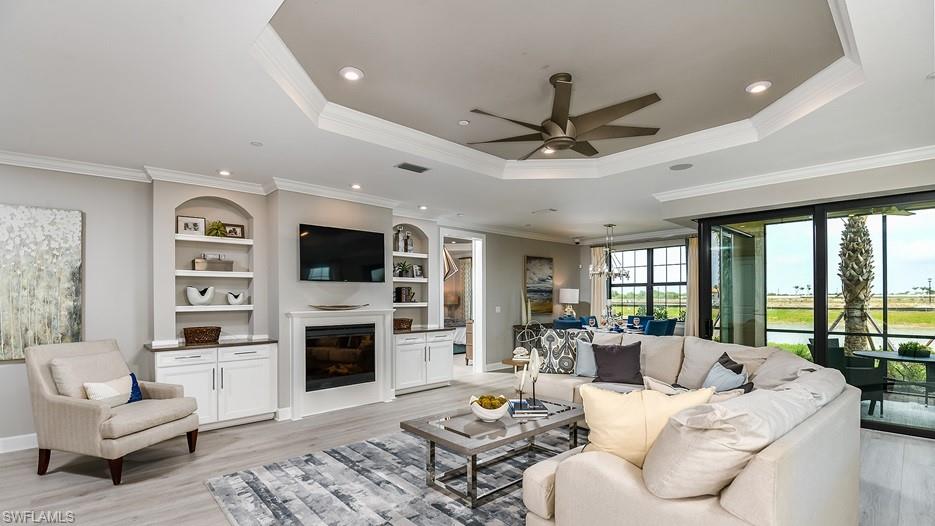 15336 Lucerna Street, Unit 101 Naples, FL 34114 - Photo 2 of 7 a living room with furniture a flat screen tv and a fireplace