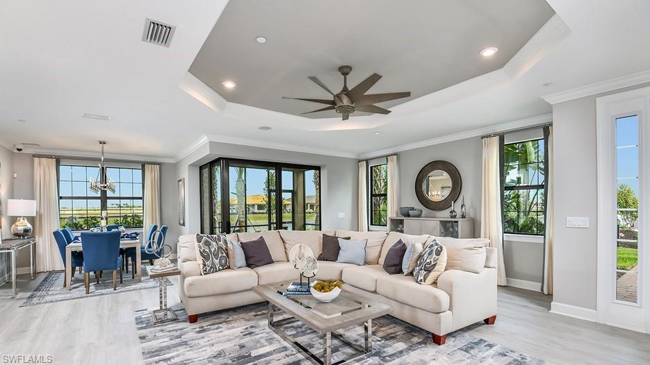 15336 Lucerna Street, Unit 101 Naples, FL 34114 - Photo 3 of 7 a living room with furniture a clock on wall and a large window