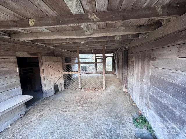 a view of backyard with wooden fence and a large tree