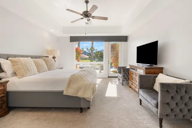 a spacious bedroom with a bed and a flat screen tv