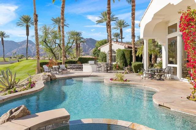 a view of a patio with a table chairs and a fire pit