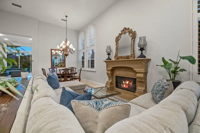 a living room with furniture a fireplace and a chandelier