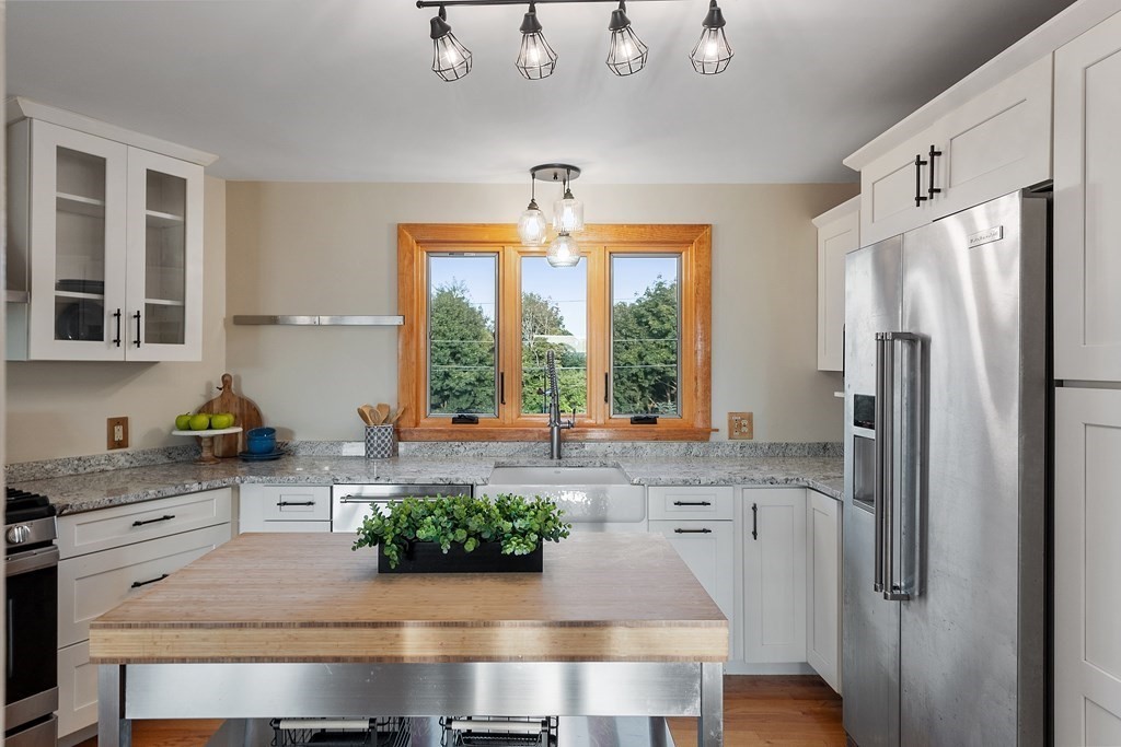 36 Osgood Road Sterling, MA 01564 - Photo 11 of 40 a kitchen with stainless steel appliances granite countertop a refrigerator a sink a stove and white cabinets