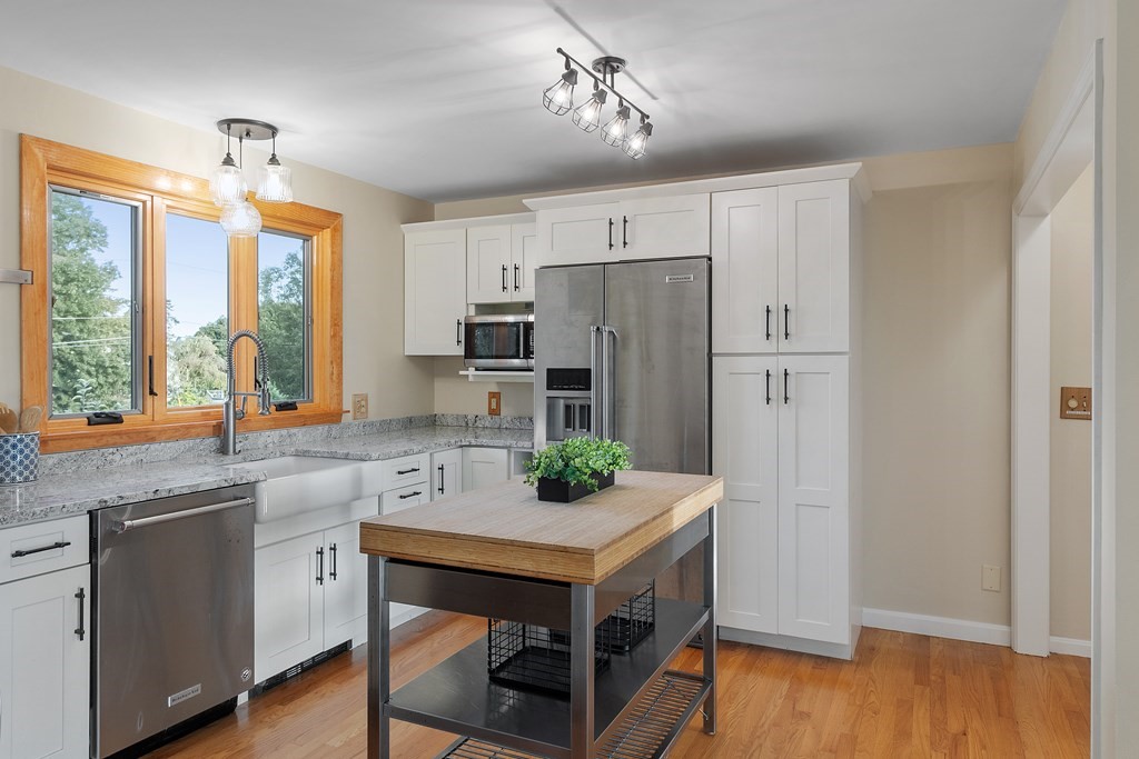 36 Osgood Road Sterling, MA 01564 - Photo 10 of 40 a kitchen with stainless steel appliances a stove a refrigerator and a sink with wooden floor