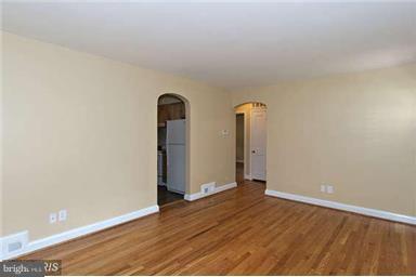 1248 June Road Baltimore, MD 21227 - Photo 3 of 18 an empty room with wooden floor and mirror