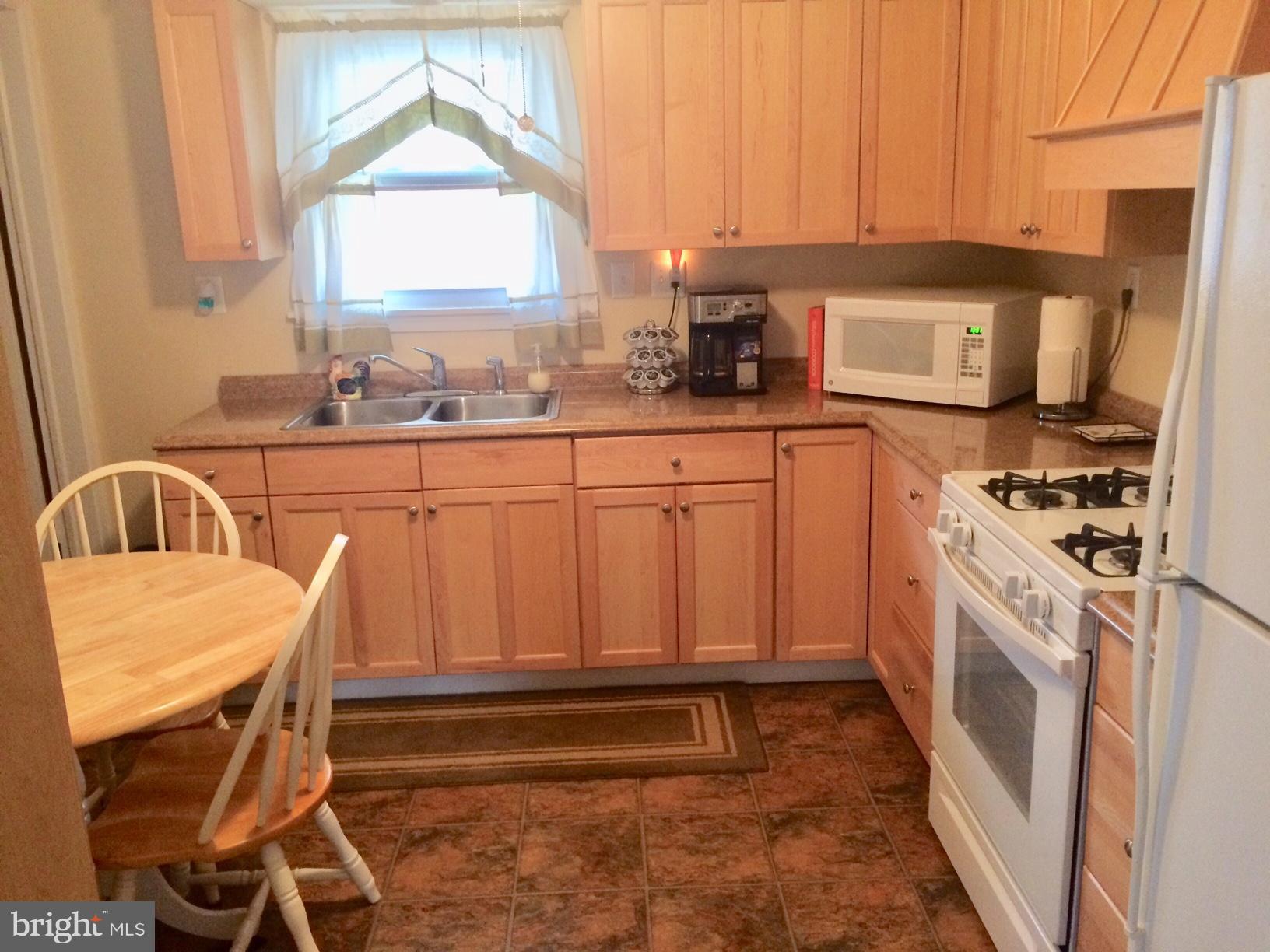 1248 June Road Baltimore, MD 21227 - Photo 5 of 18 a kitchen with a stove a sink and a refrigerator