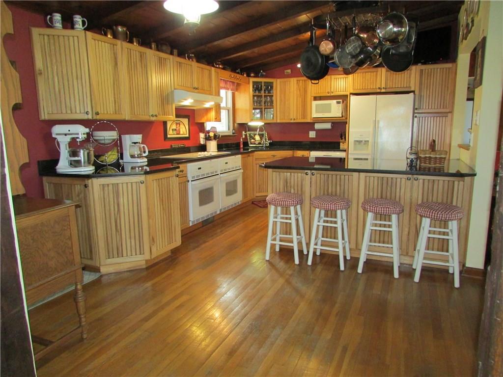 136 McKenzie Road Clinton, PA 15026 - Photo 6 of 25 Kitchen with hardwood floors, wood ceiling. Hickory cabinets, island and granite counter tops. Electric cooktop and dual ovens.