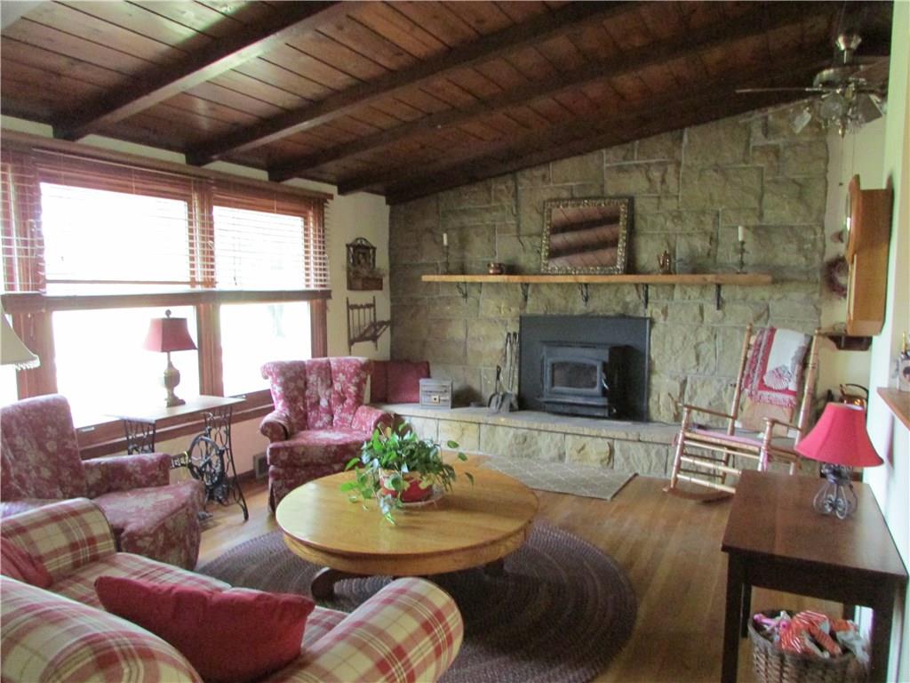 136 McKenzie Road Clinton, PA 15026 - Photo 10 of 25 Livingroom with stone fireplace, wood mantel, hardwood floors and ceiling.