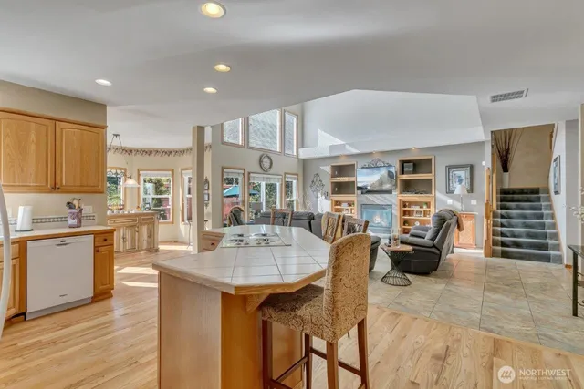 a open kitchen with stainless steel appliances granite countertop a stove and white cabinets