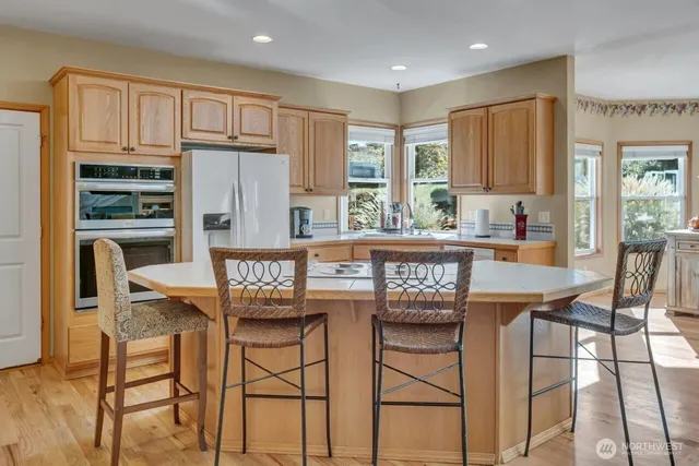 a kitchen with granite countertop a table chairs stove and refrigerator