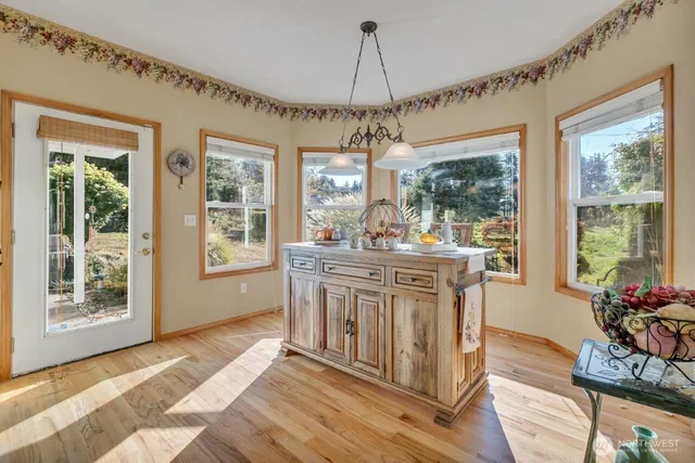 a kitchen with stainless steel appliances granite countertop a stove a sink dishwasher and a refrigerator with wooden floor