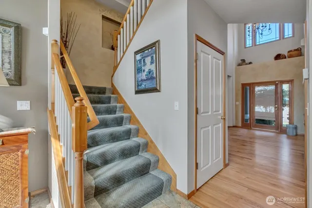 a view of staircase with lots of frames on wall and a wooden floor