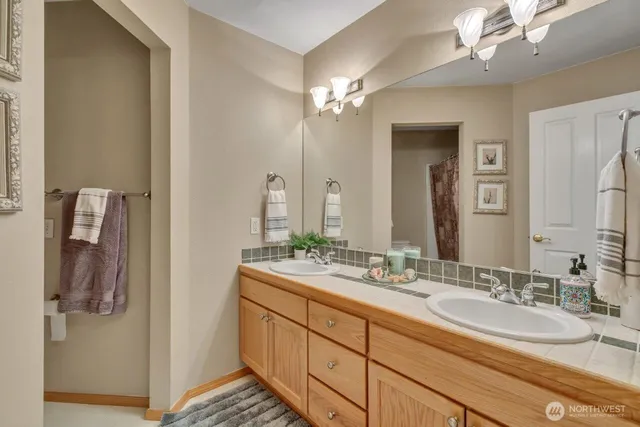 a bathroom with a double vanity sink a mirror and a shower