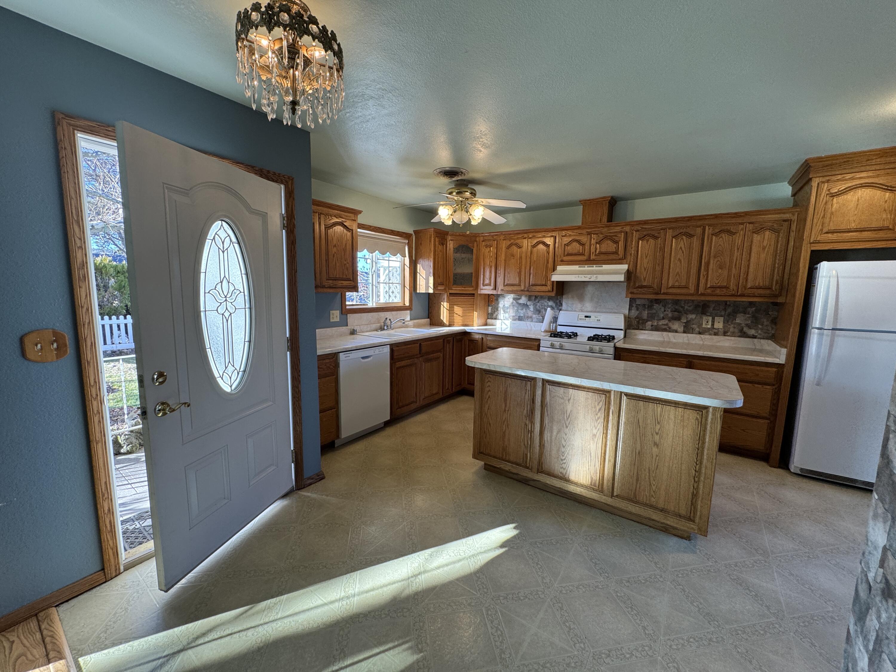 20525 Hudson Street Burney, CA 96013 - Photo 15 of 58 a kitchen with stainless steel appliances granite countertop a refrigerator a stove a sink dishwasher and white cabinets with wooden floor