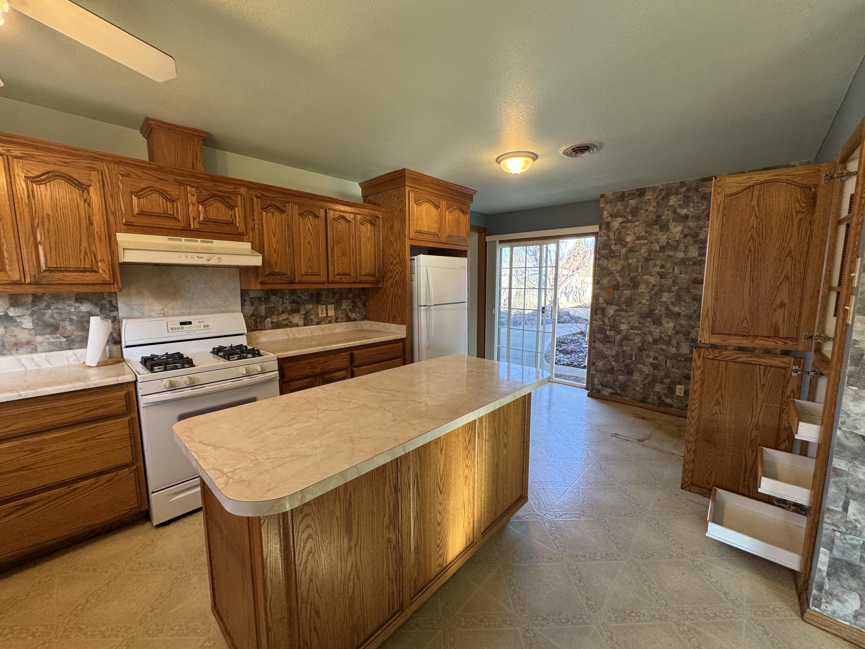 20525 Hudson Street Burney, CA 96013 - Photo 18 of 58 a kitchen with stainless steel appliances granite countertop a refrigerator a stove and a sink with wooden cabinets