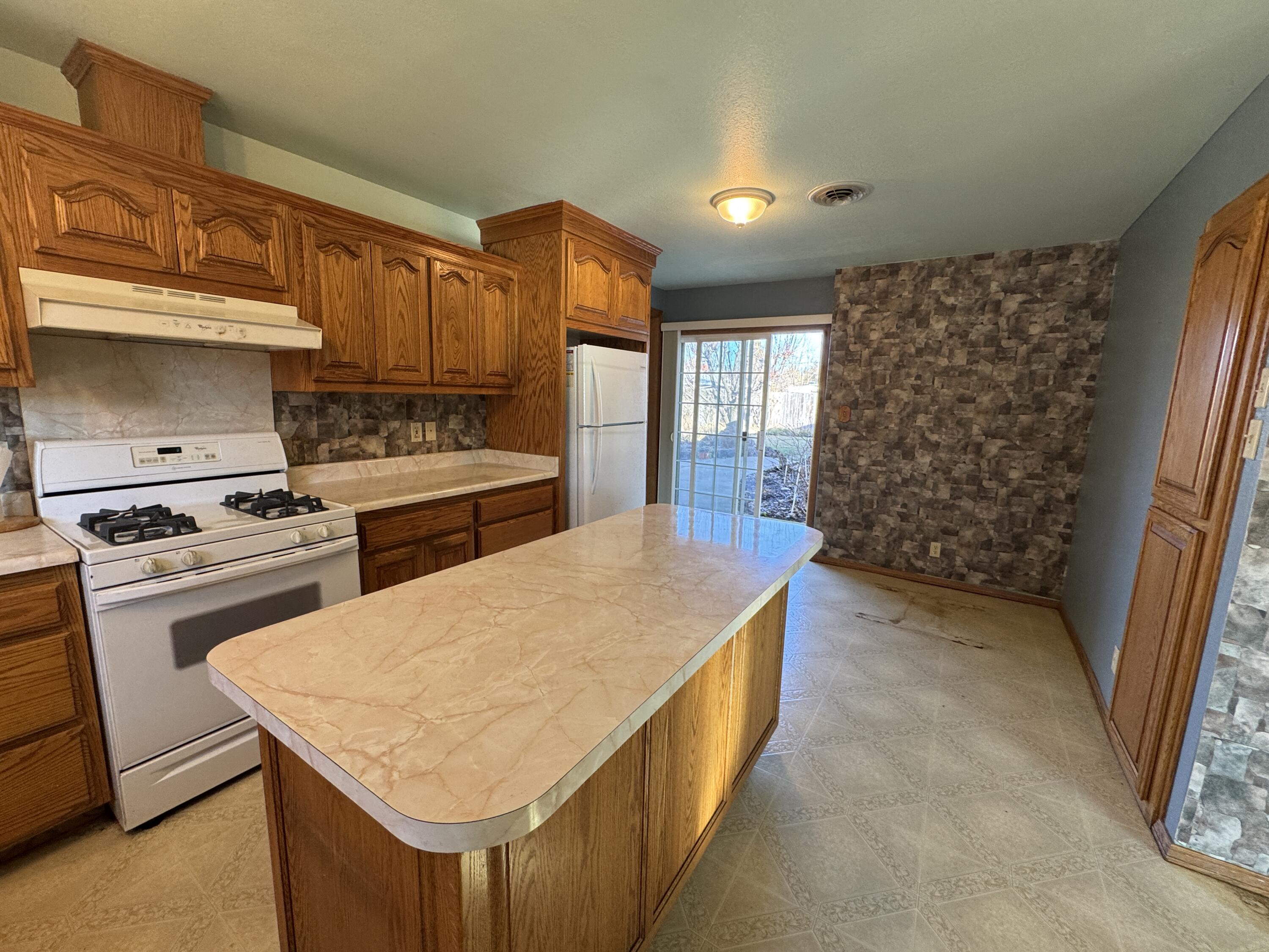 20525 Hudson Street Burney, CA 96013 - Photo 22 of 58 a kitchen with a stove a sink and a refrigerator