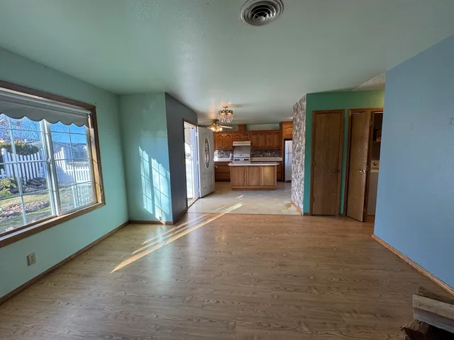 a kitchen with stainless steel appliances granite countertop a refrigerator a stove and a sink with wooden cabinets