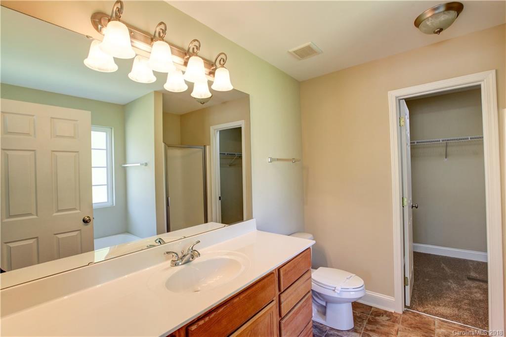 3713 Austin Road Monroe, NC 28112 - Photo 15 of 19 a bathroom with a granite countertop sink a toilet and a mirror