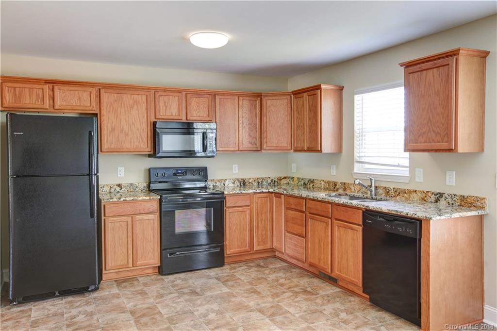 3713 Austin Road Monroe, NC 28112 - Photo 10 of 19 a kitchen with stainless steel appliances granite countertop a stove top oven a refrigerator and a sink with granite countertops
