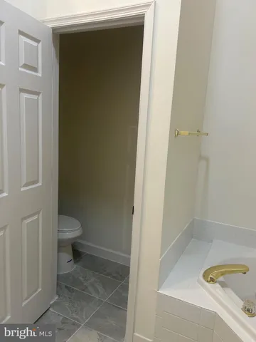 a bathroom with a granite countertop toilet and a sink