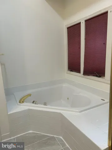 a bathroom with bathtub and window