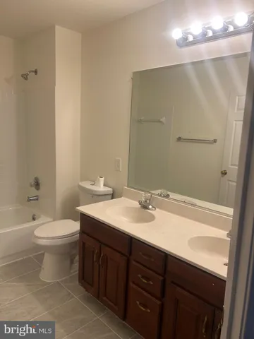 a bathroom with a double vanity sink mirror and toilet