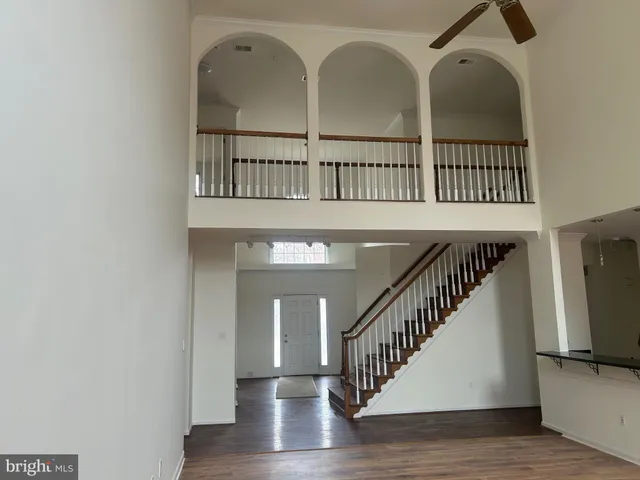 a view of staircase with railing and a chandelier