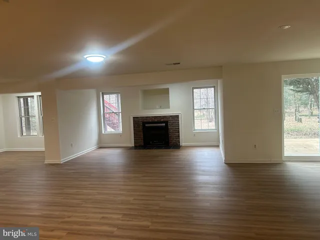 an empty room with wooden floor and fireplace