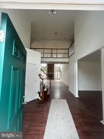 a view of a hallway with wooden floor and stairs