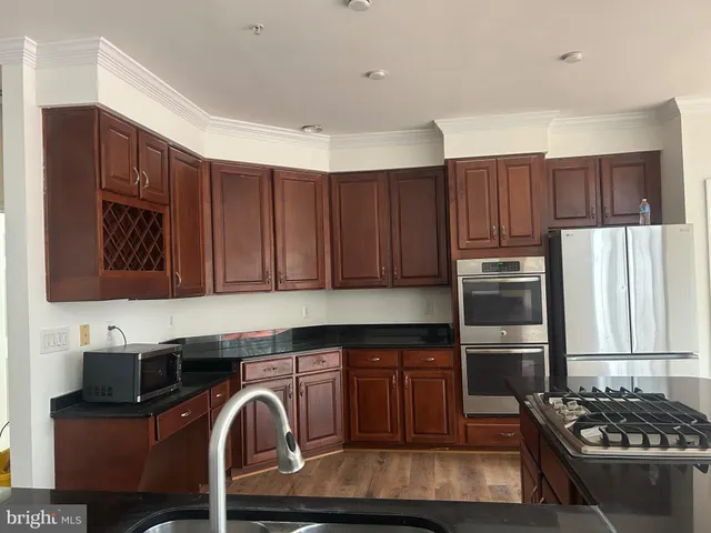 a kitchen with wooden cabinets and a stove top oven