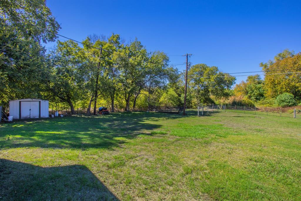 4930 Spring Valley Road Lorena, TX 76655 - Photo 32 of 34 Expansive grass lawn with mature trees and a dedicated storage shed