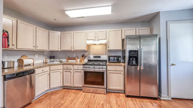 a kitchen with a refrigerator sink and cabinets