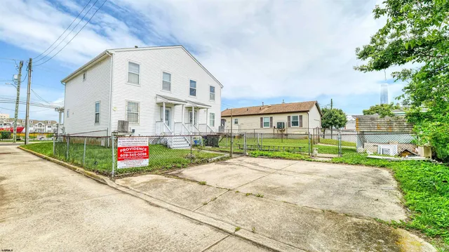 a view of an white house with wooden fence