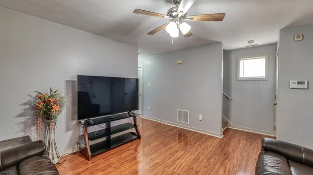 a bedroom with wooden floor and a potted plant