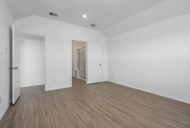a view of an empty room with wooden floor