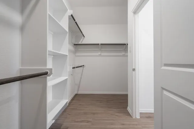 a view of walk in closet with empty racks