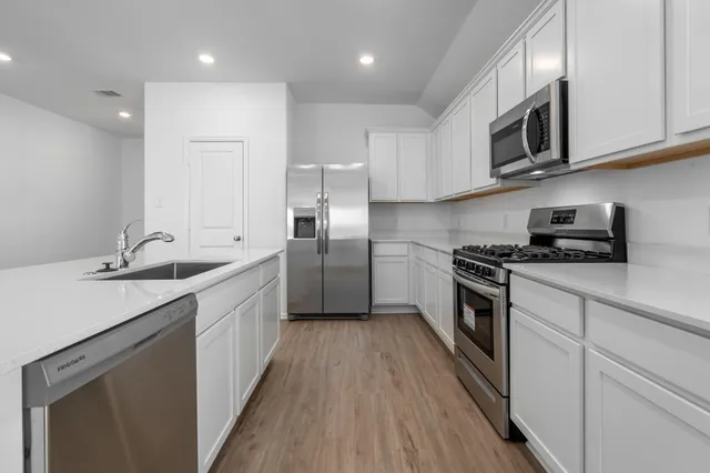 a kitchen with stainless steel appliances granite countertop a sink stove and refrigerator