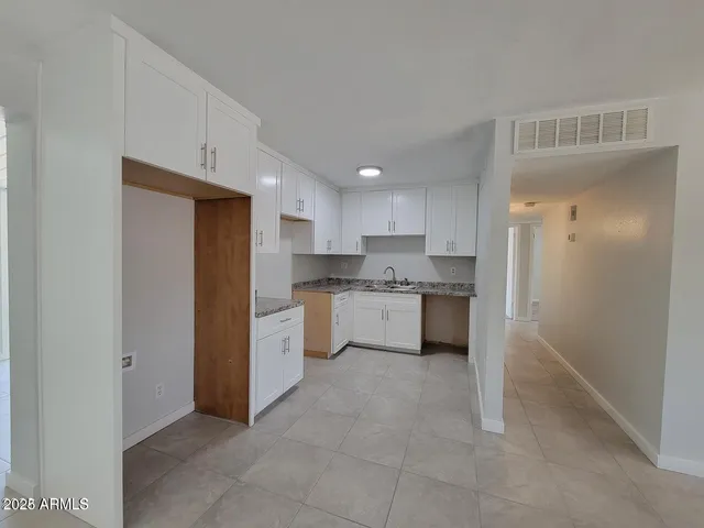 a kitchen with white cabinets and white appliances