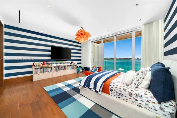 a bed room with a bed television and a large window