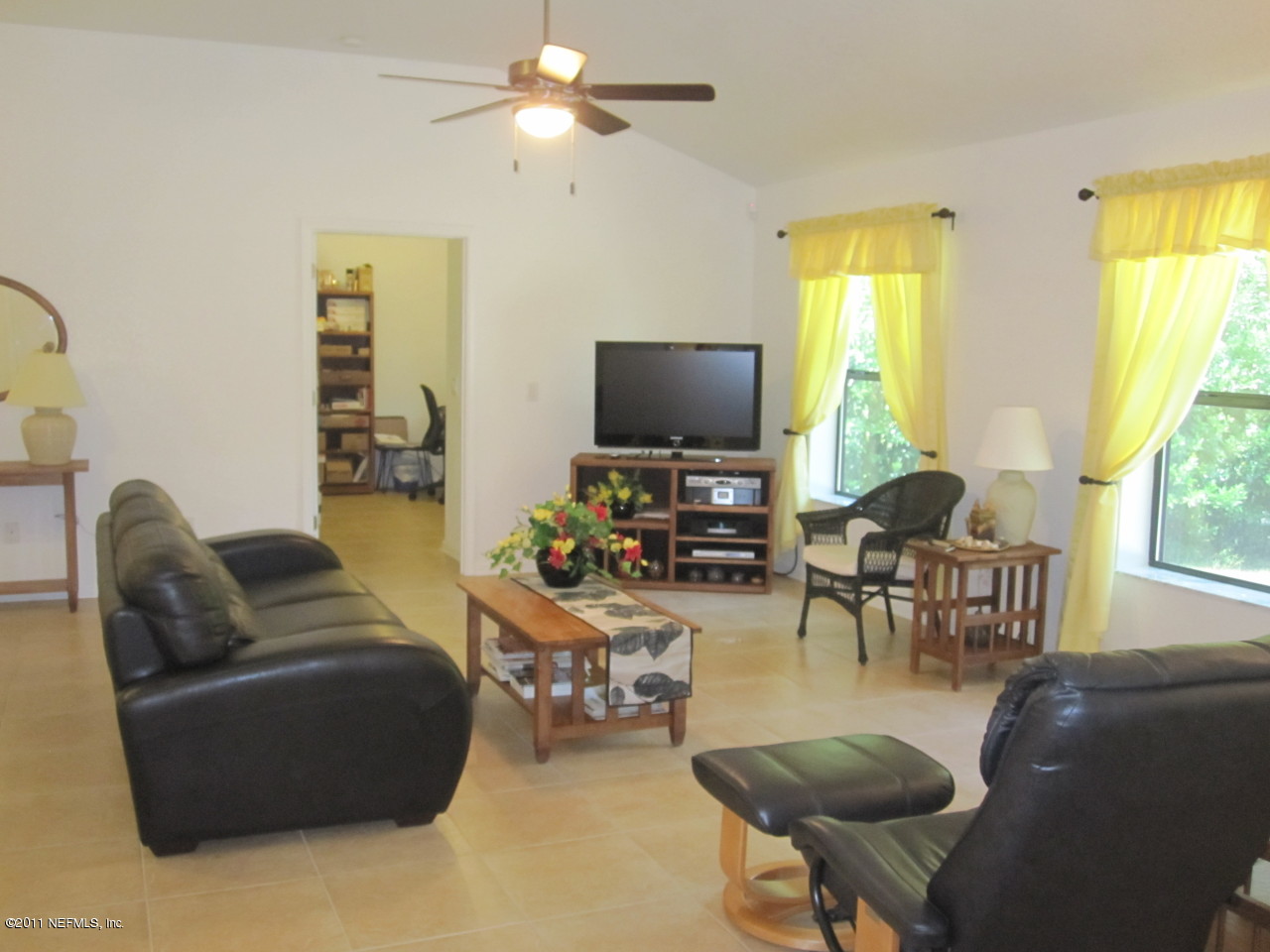 12589 Knotah Road Jacksonville, FL 32258 - Photo 11 of 25 a living room with furniture a flat screen tv and a large window