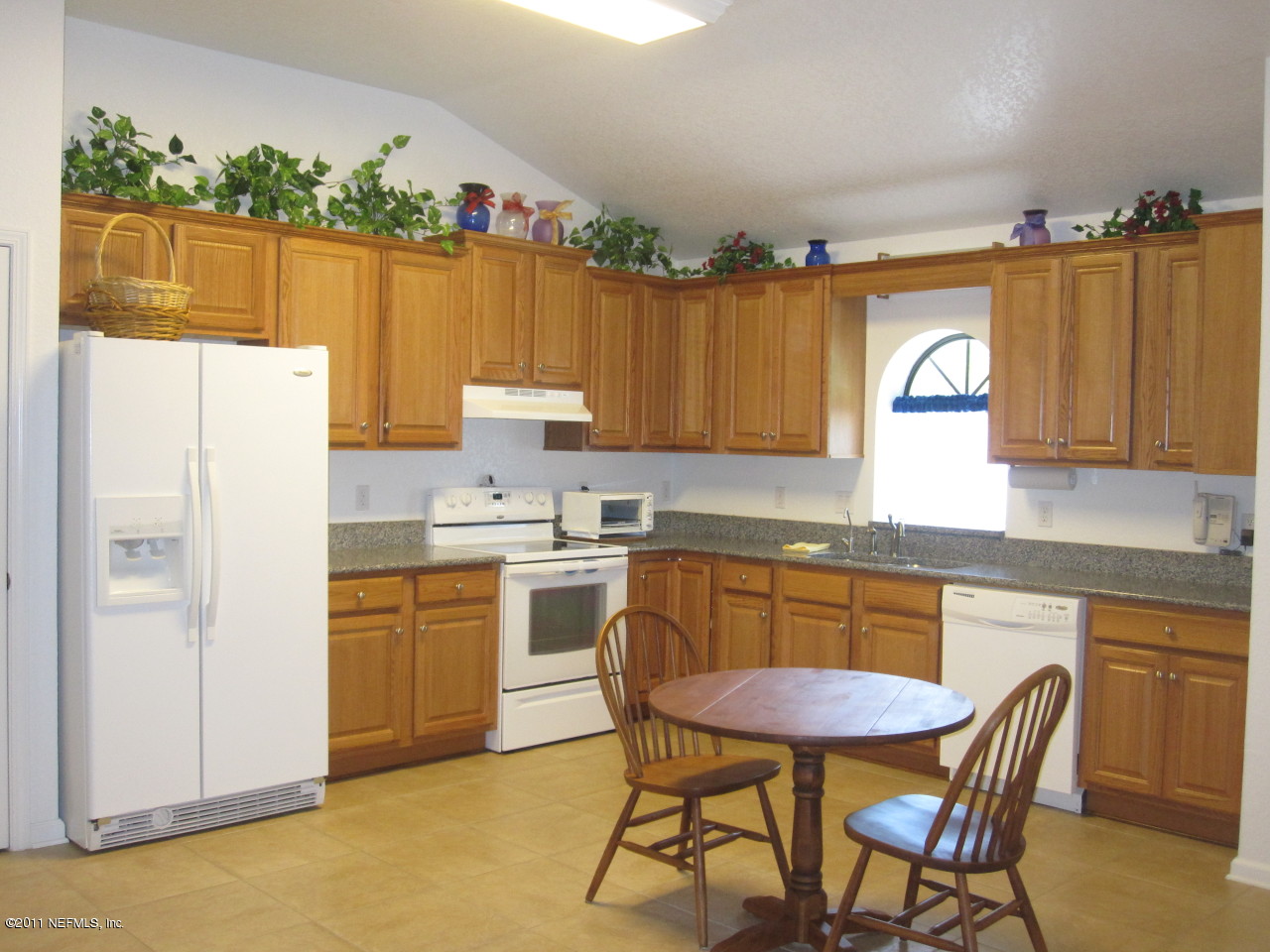 12589 Knotah Road Jacksonville, FL 32258 - Photo 2 of 25 a kitchen with a refrigerator a stove a sink cabinetry and a dining table