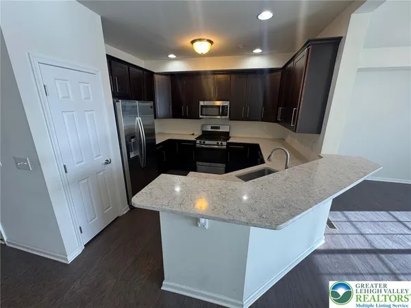 a kitchen with stainless steel appliances granite countertop a sink a stove a refrigerator a sink and cabinets