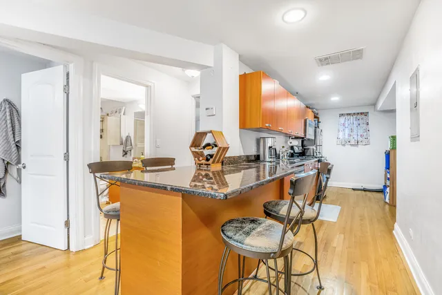 a view of a kitchen with kitchen island granite countertop lots of appliances and cabinets